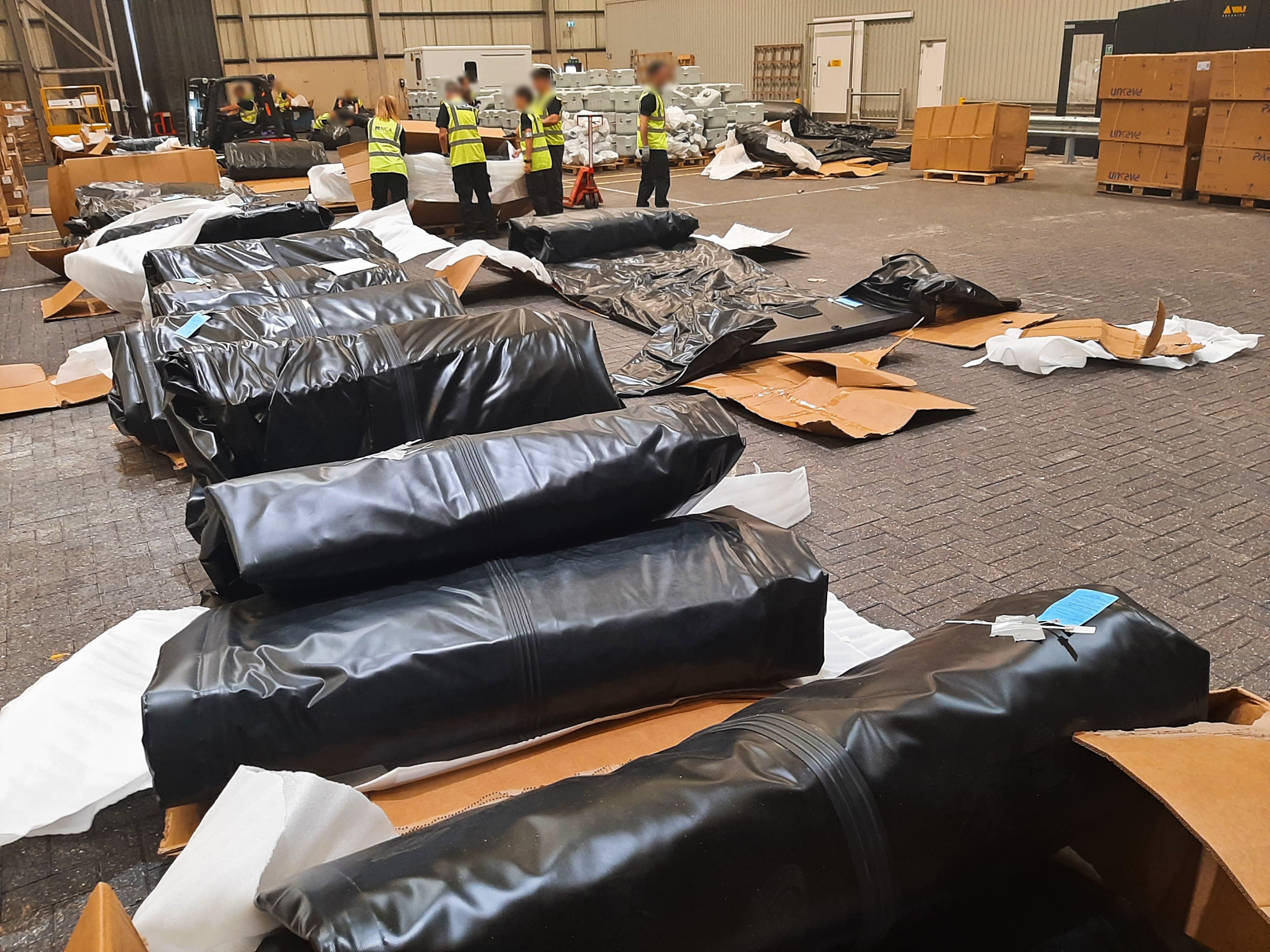 Small boats rolled up and laid out on warehouse floor